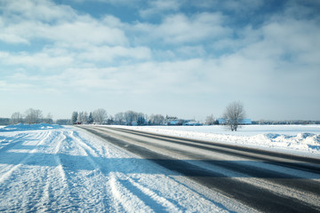 Asphalt road in snowy winter on beautiful frosty sunny day