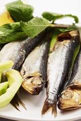 Smoked fishes on plate closeup