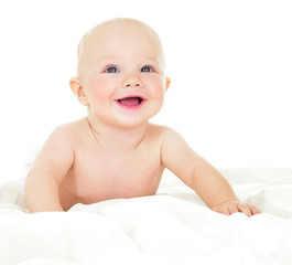 Beautiful smiling baby lying on his stomach in bed. One, isolate