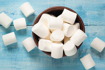 White marshmallow in  bowl on blue - obrazy, fototapety, plakaty