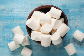 White marshmallow in  bowl on blue