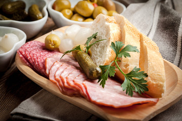 Tapas with sliced sausage, salami, olives, marinated onions, cuc
