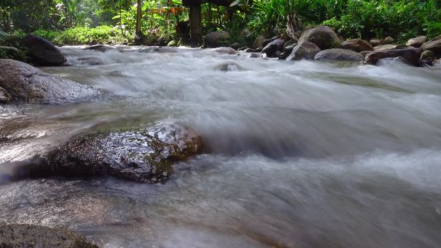 Beautiful silky water flow through stones,  Mountain stream running over rocks.