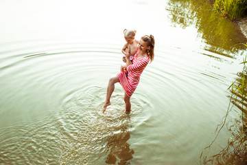 The mother with  daughter stand in  the lake