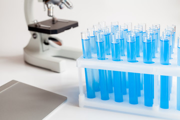 tubes with liquid and microscope on white background