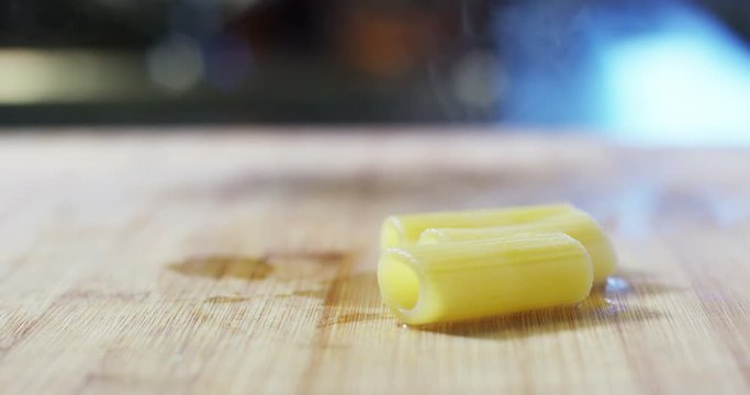 An experienced chef in a professional kitchen throws the Italian pasta in the pot to cook it while the water bubbles in slow motion. the concept of nature, Italy, food, diet and bio.