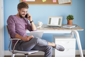 Digital devices used by young and cheerful man