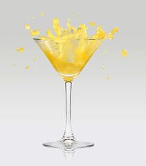 Orange juice splashing out of glass