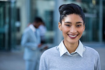 Smiling businesswoman standing in office - 124714476