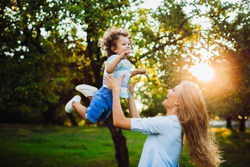Fototapeta premium beautiful young mother with her son having fun in a park