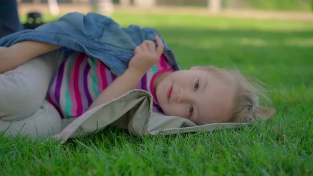 Little girl resting on the grass.
