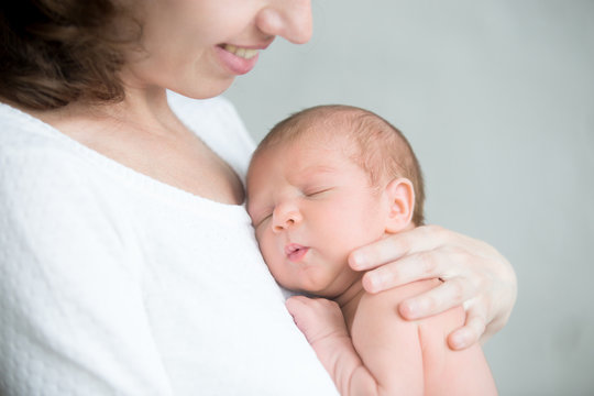 Portrait of a newborn hold close at mother s breast, close up. Family, healthy birth concept photo