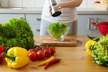 young woman making salad in the kitchen
