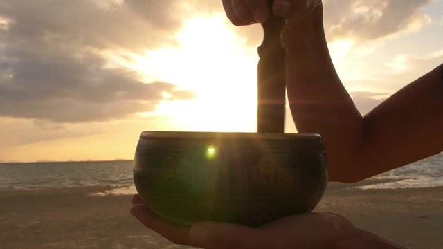 Meditation with Singing Bowl at Beach at Sunset