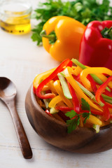 Celery, red and yellow pepper paprika vegetarian salad in a bamboo bowl on a light background.Top view.  Space for text. Selective focus.