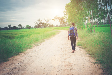 Obraz premium Back of young hipster man with backpack on his shoulder walking
