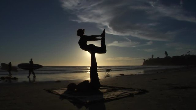 Acroyoga lifestyle beach sunset, silhouette beauty shot.