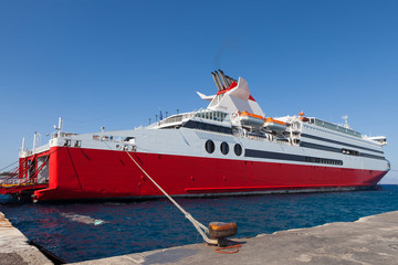Naklejka premium Large red and white ferry docked at a port
