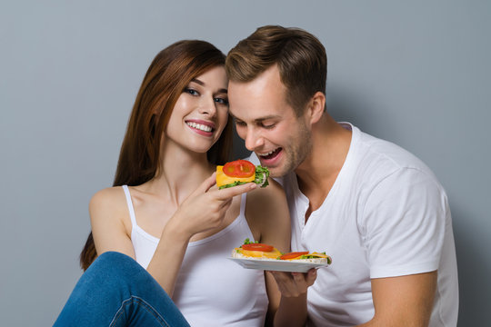 Couple eating crispbread with cheese and tomato