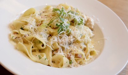 Tagliatelle pasta with cheese sauce, bacon, parsley and Parmesan