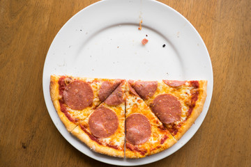 sliced salami pizza on a white plate