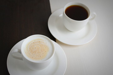 Two cups of black and white coffee