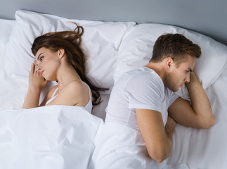 Unhappy young couple on the bed