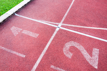 Numbers starting point on red running track,running track and green grass,Direct athletics Running track at Sport Stadium