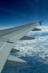 Fototapeta na wymiar Aile d'avion en vol vue à travers un hublot passager, volets fermés