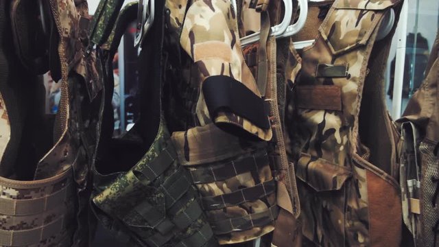 In the Army store on hangers hanging new bulletproof vests sand-colored and khaki color