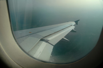 Aile d'avion en vol vue à travers un hublot passager