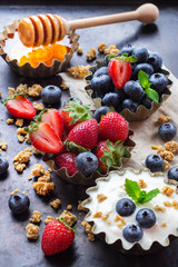 Homemade muesli granola and yogurt with berries on rusty table