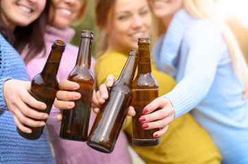 Group of young woman toasting with bottle of beer