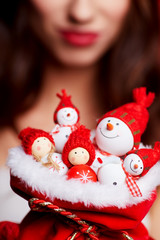 Small snowmen in red hats in the bag at the hands of a model. Ch