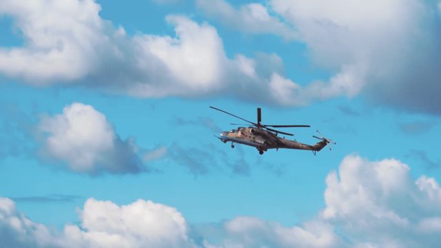Attack helicopter Mi-24 flying on a background of blue sky and clouds. Includes audio. Contains audio