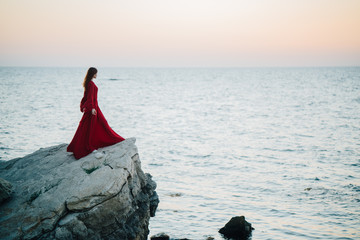 Woman on a rock in a red dress
