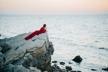 Woman on a rock in a red dress
