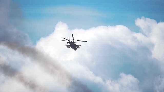 Reconnaissance and attack helicopter of the new generation Ka-52 "Alligator" flying on a background of blue sky and clouds. Includes audio. Contains audio