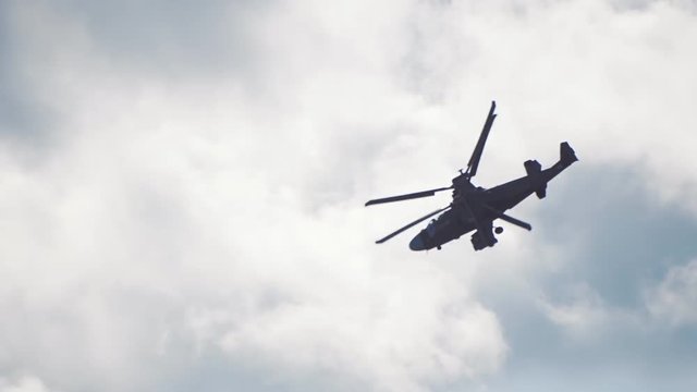 Reconnaissance and attack helicopter of the new generation Ka-52 "Alligator" flying on a background of blue sky and clouds. Includes audio. Contains audio