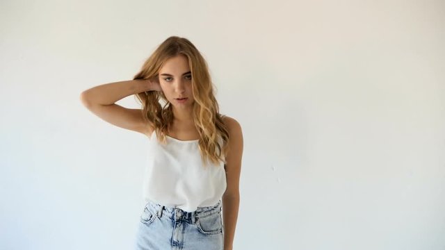 young model girl in white tank top and short blue Jean shorts