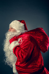 Santa Claus carries a bag with gifts.