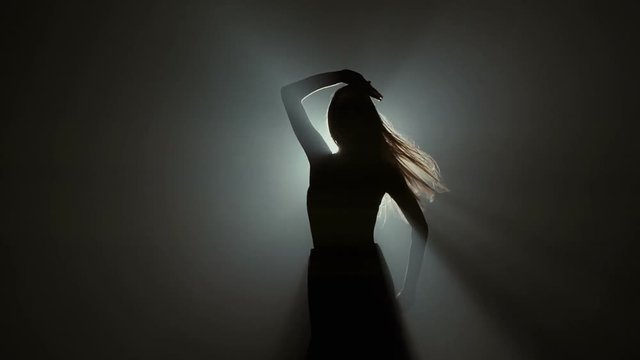 Silhouette of a ballet dancer in black studio background