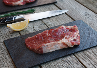 Fototapeta na wymiar Raw beef steak on dark wooden table background