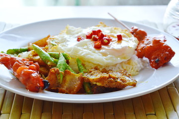 spicy stir fried crispy pork curry with egg topping chili on rice