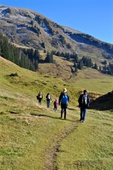 Obraz premium Wandergruppe wandert im Herbst auf dem Wanderweg in den Schweizer Alpen / Berge