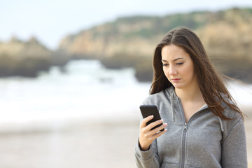 Sad teenager checking mobile phone
