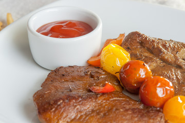 Vegetarian steak made from vegan meat seitan, with cherry tomatoes