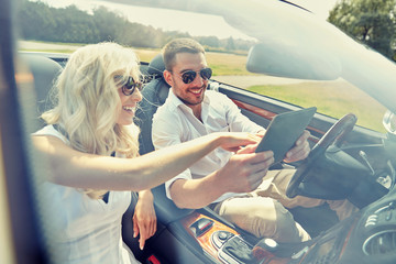 happy couple with tablet pc in cabriolet car