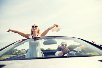 happy man and woman driving in cabriolet car