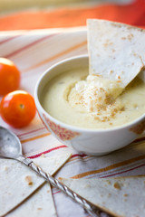 Vertical shot of vegetarian hummus - mediterranen dish. Hummus is garnish with bread and vegetables